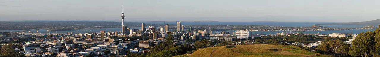 The Skyline of Auckland City, in the foreground a part of Mt. Eden is visible, left in the background is the Auckland Harbour Bridge. Panora