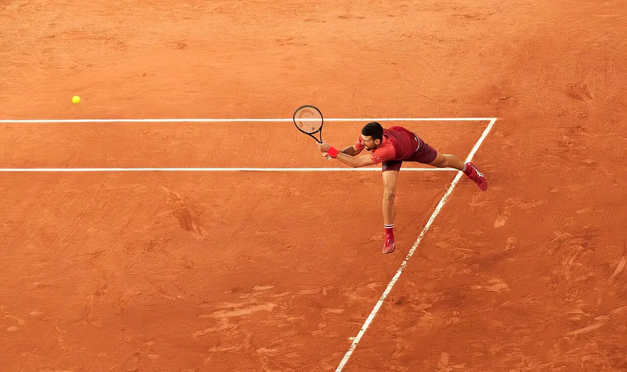 Novak Djokovic returning a serve with his backhand at the 2024 French Open (Roland-Garros), during his first round match against Pierre-Hugu